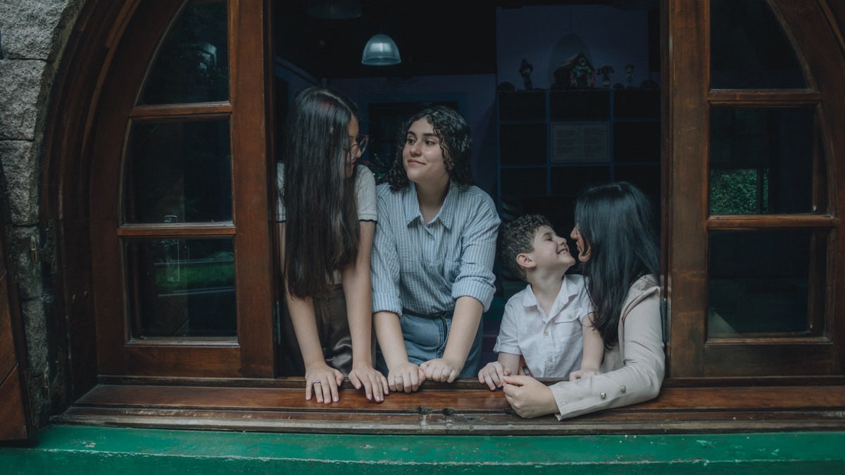 A family spending quality time by a window, engaged in conversation and smiles.